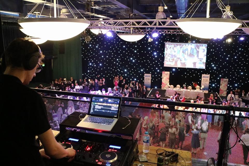 Alex Healey DJing at a live event with a crowded dancefloor